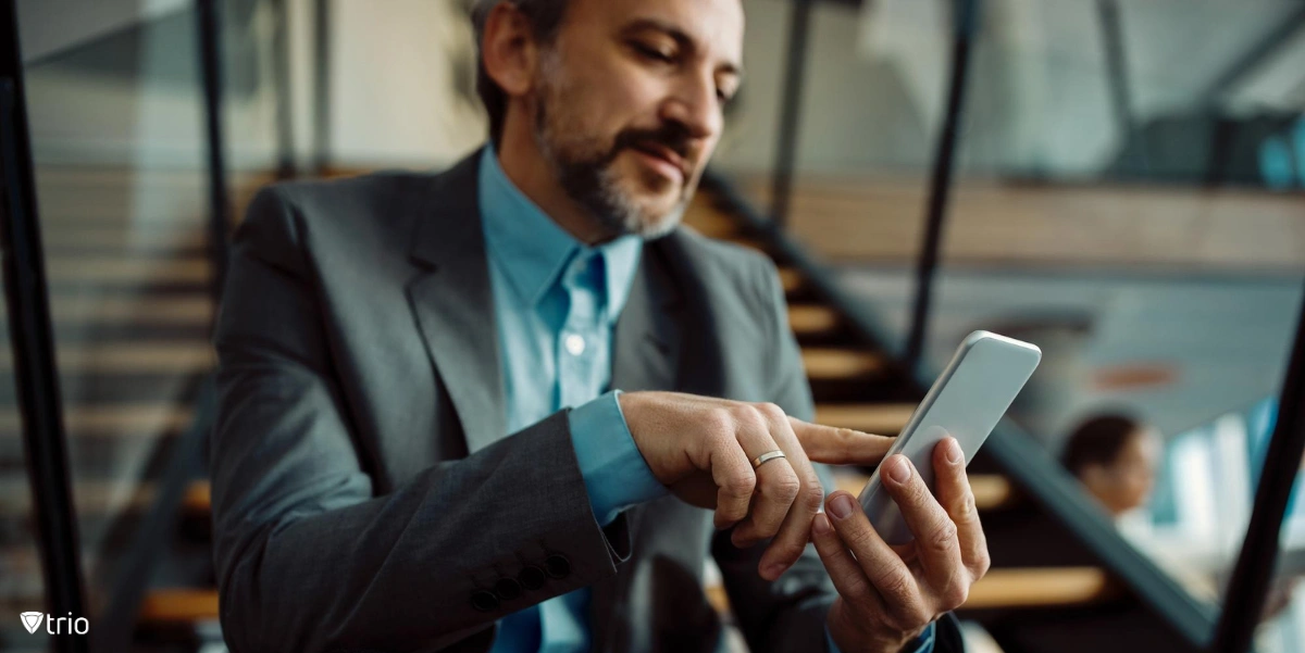 Man using phone sitting on stairway of office