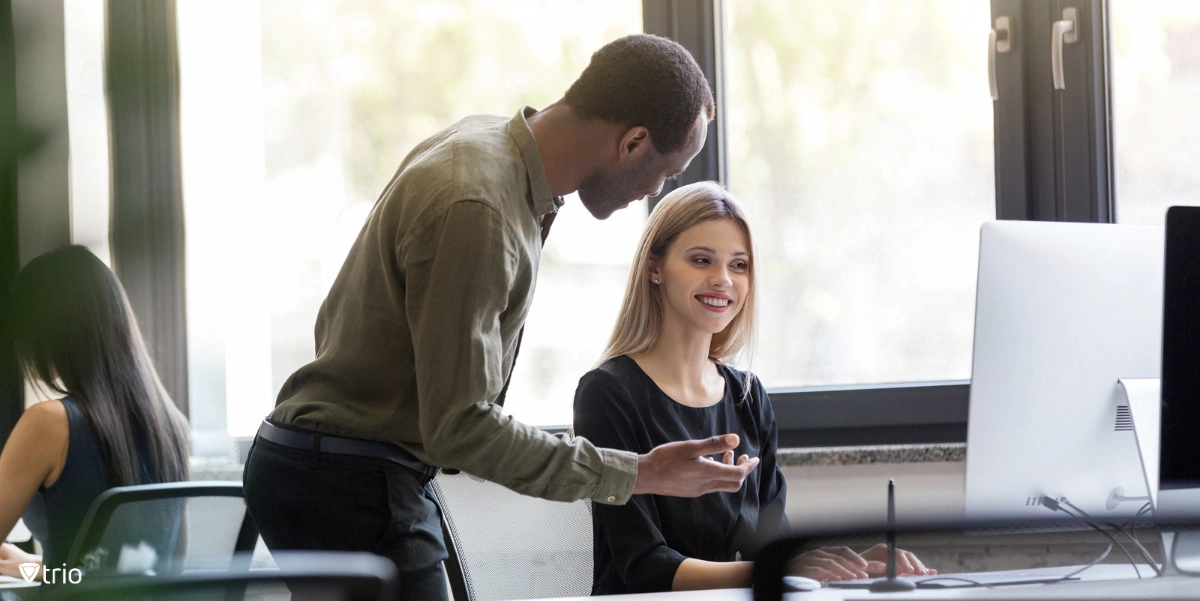 Man talking to woman working behind a desktop