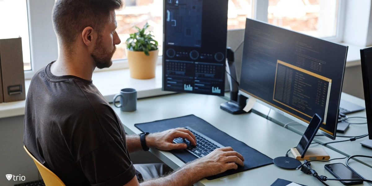 IT employee working on a computer with two monitors