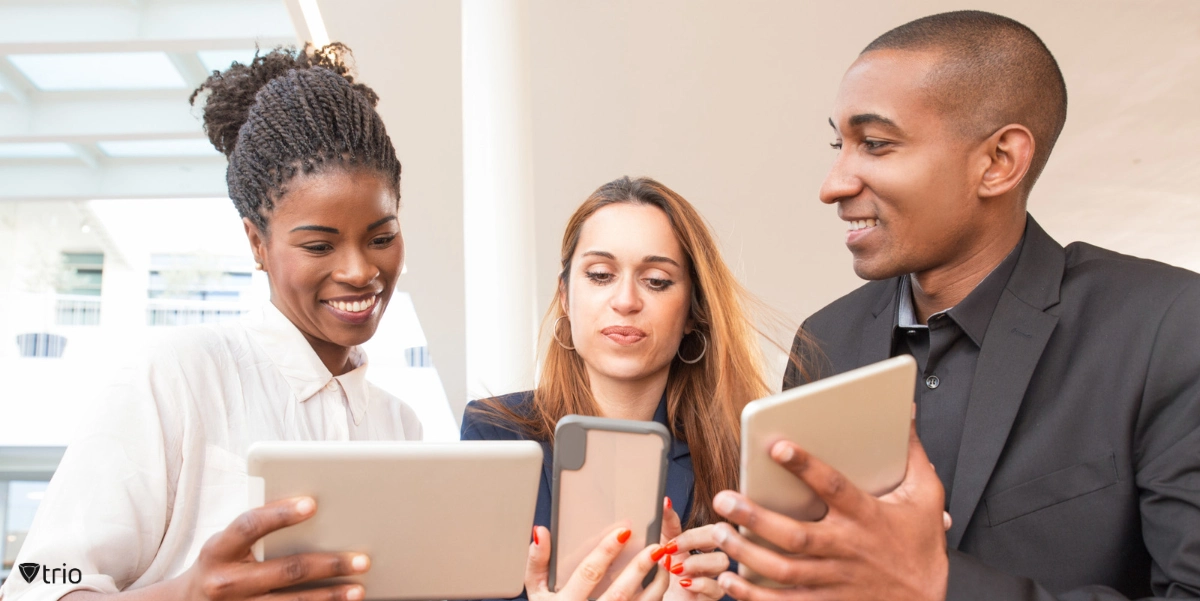 Employees showing their mobile device and tablets to each other