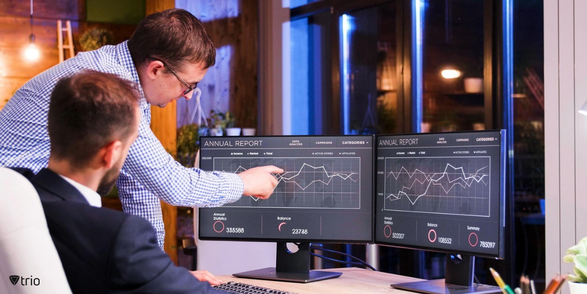 Master data collection by two employees sitting behind a monitor checking analytics