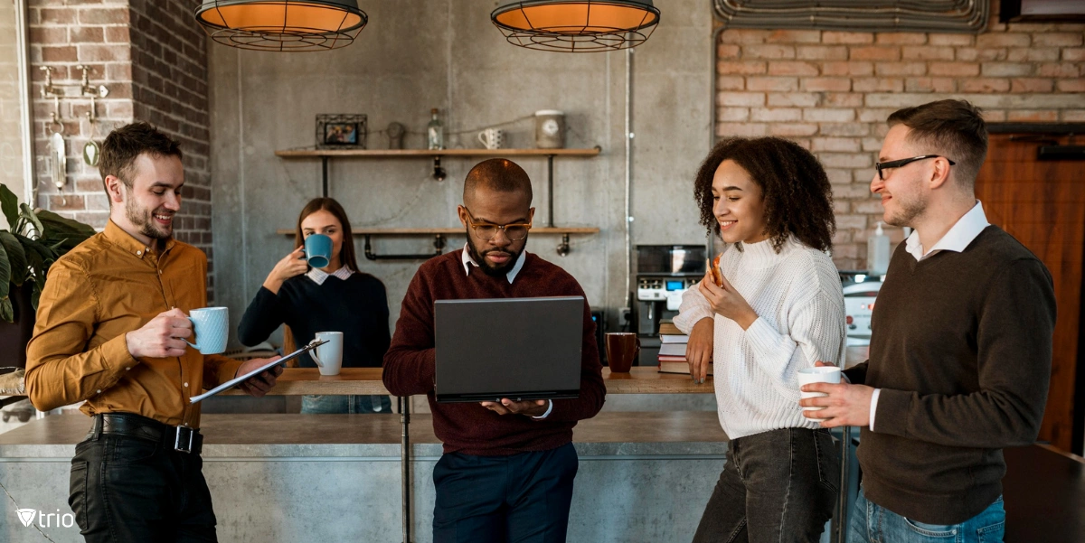 Employees around a kitchen island using devices