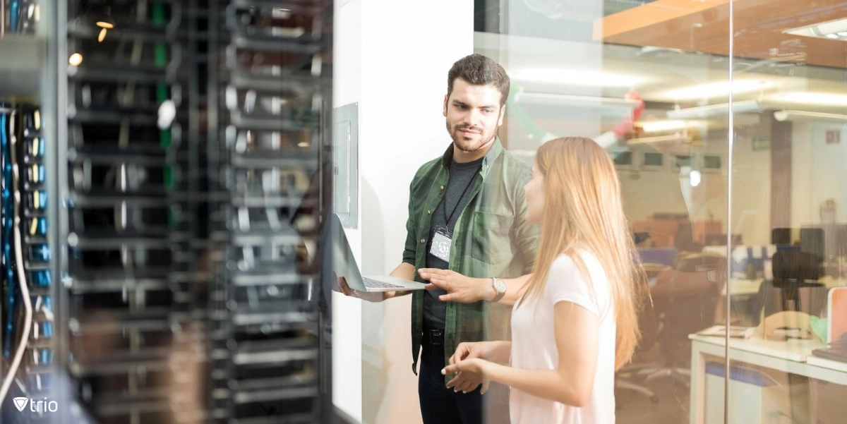 IT administrator talking to an employee in front of servers