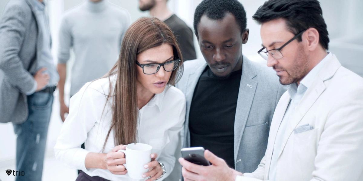 Employees showing their mobile device next to each other