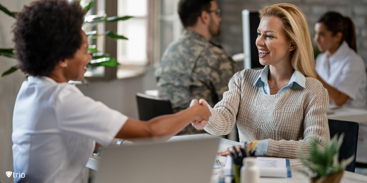 New hire being welcomed at desk by HR employee