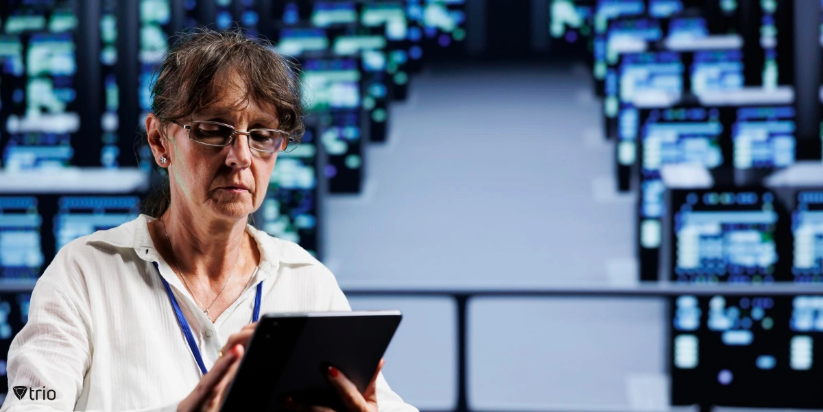 Eine ernste Frau mit Brille, die ein Tablet in den Händen hält.