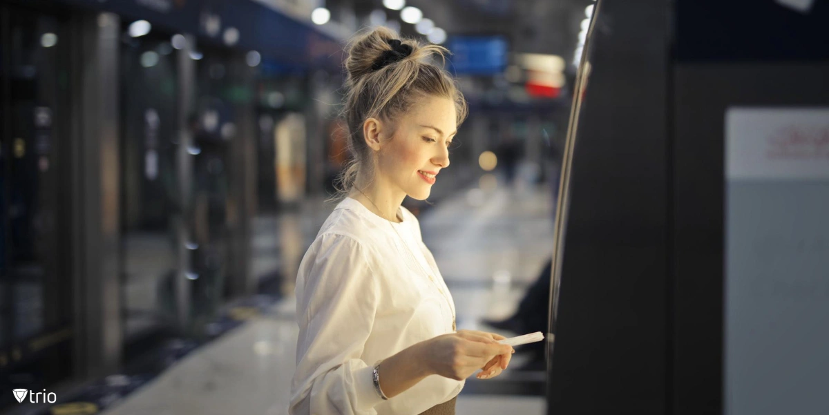 Woman buying a subway ticket through an interactive kiosk software.