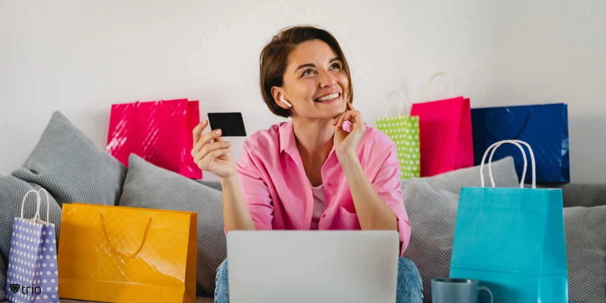 Frau beim Online-Shopping und glücklich vor dem Laptop auf dem Sofa