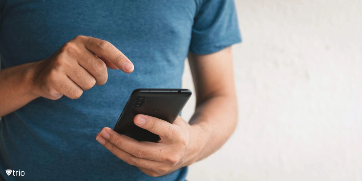 Close-up of a man in a t-shirt using a smartphone