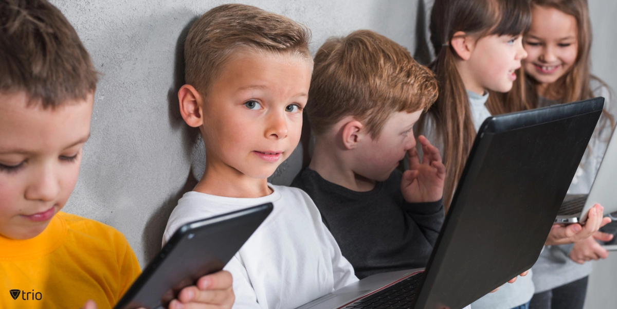 Some kids standing with tablets and laptops in their hands