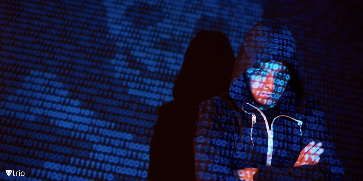 Ein vermummter Hacker interagiert in einer dunklen Umgebung mit virtuellen Bildschirmen