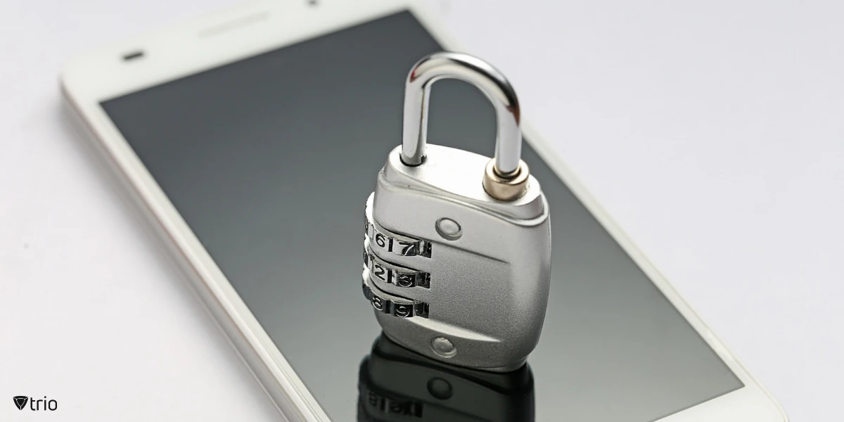 Nahaufnahme eines Smartphone-Bildschirms mit einem physischen Vorhängeschloss darauf, das die Verschlüsselung symbolisiert