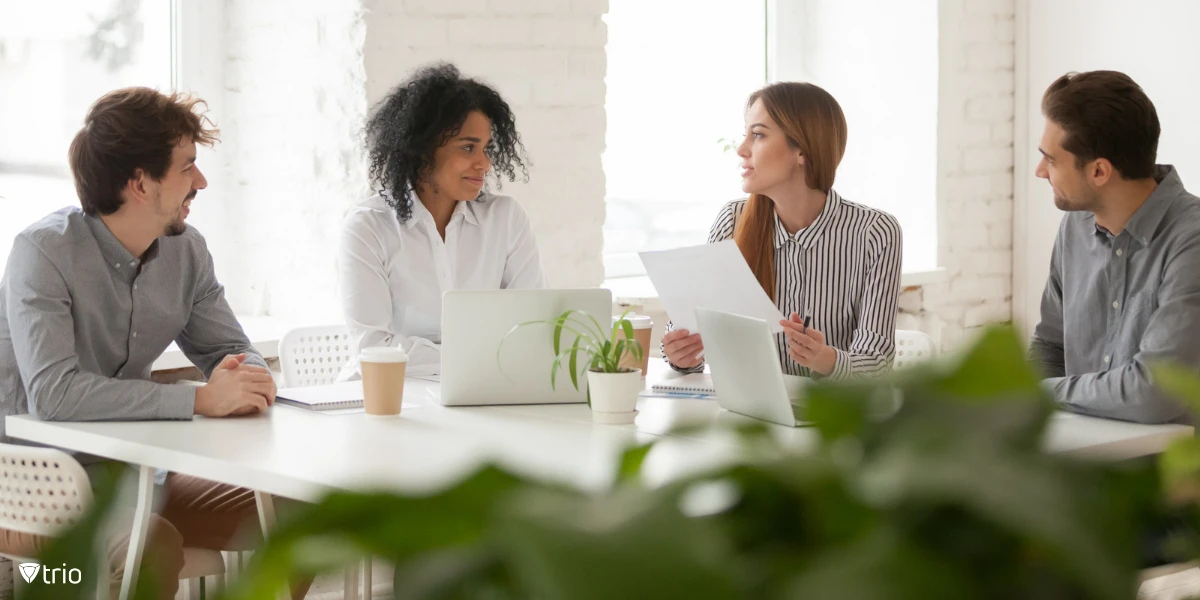 Ein vierköpfiges Team diskutiert in einem White Office, wie Cybersicherheits-Frameworks implementiert werden können