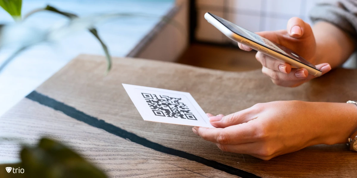 A woman scanning a QR code printed on a page with her smartphone.