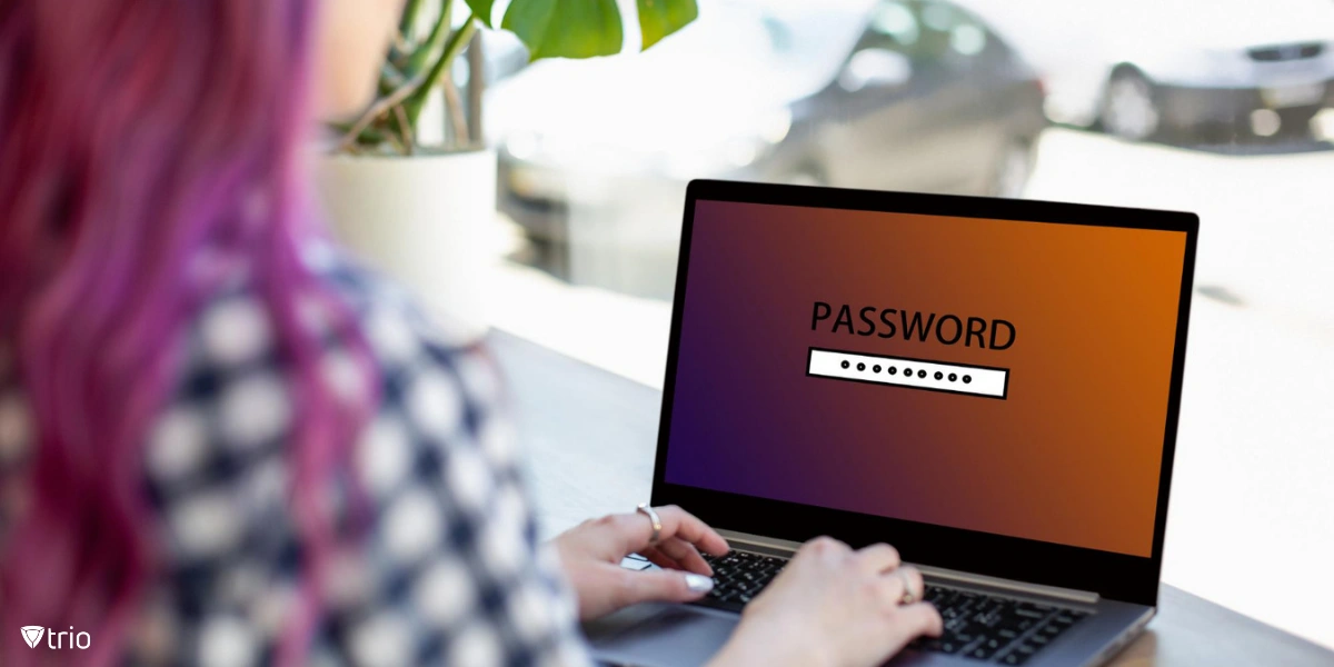 Rückansicht einer Frau, die in einem Café sitzt, während sie auf einem Laptop mit Passwort-Anmeldebildschirm tippt