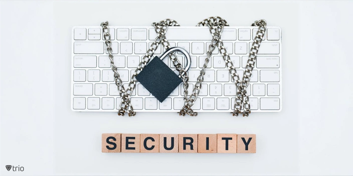 Eine Computertastatur wird in Ketten gewickelt und mit einem Vorhängeschloss gesichert. Unterhalb der Tastatur buchstabieren Holzklötze das Wort "SECURITY"