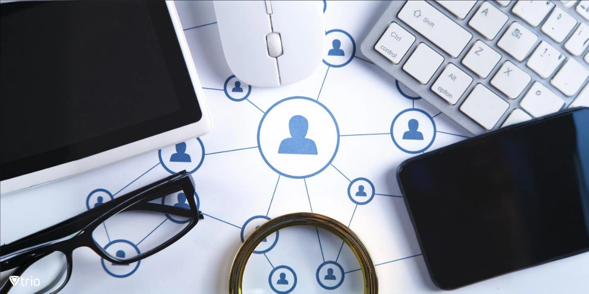 A central figure icon connected to others via a network of lines. Surrounding items include a computer keyboard, a mouse, a smartphone, glasses, a magnifying glass, and a tablet.