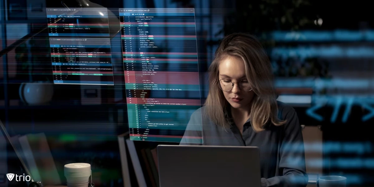 A focused woman working on a laptop in a dimly lit environment, surrounded by floating lines of code and digital overlays