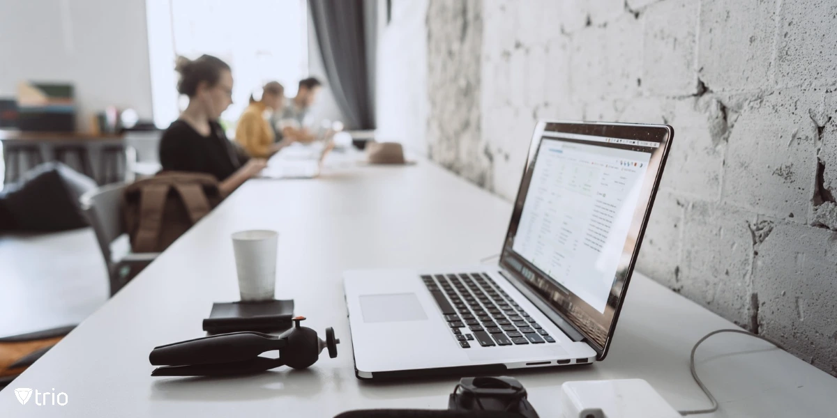 workspace with devices and people working in the background