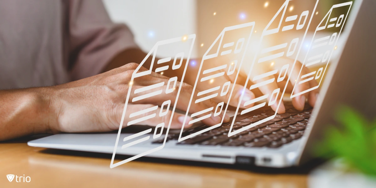 A man working on a laptop at a home office or coworking space, with digital file icons floating above the keyboard