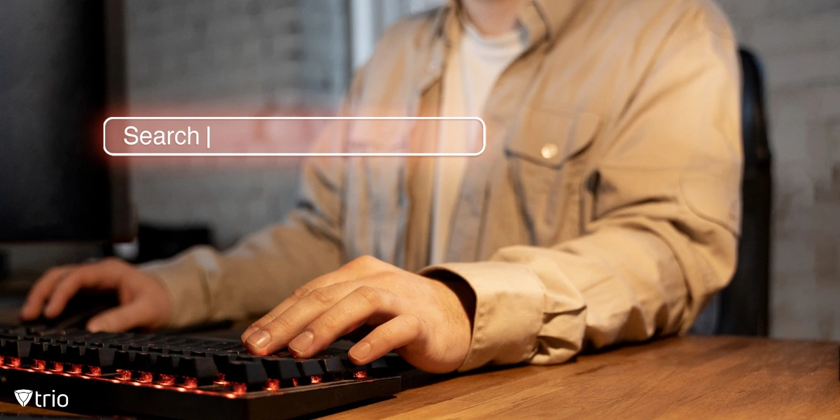 Hands of a man typing on a keyboard with an overlay of a search bar.