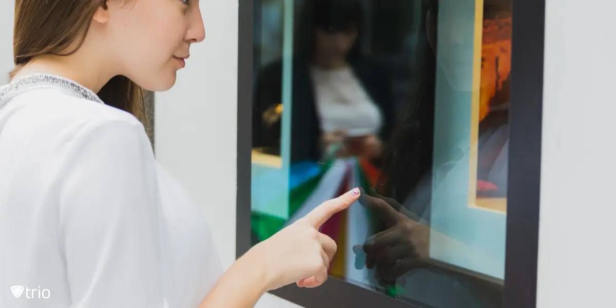A woman interacting with a big screen in a public place.